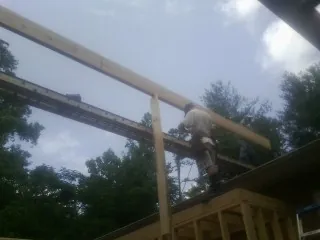 Carpenter setting a ridge beam over a new addition frame — Ice Dam Removal by Roofing Brothers in Frenchville