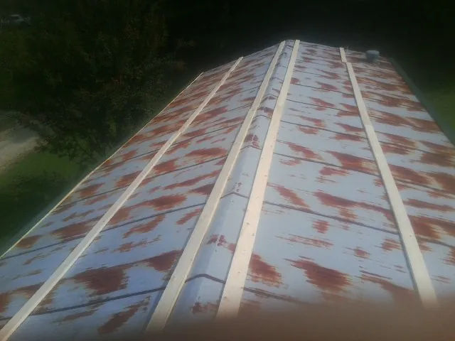 Rusted metal roof panels with new wood purlins before replacement — Storm Damage Roof Repair in Frenchville by Roofing Brothers