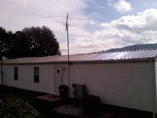New metal roof on a single wide mobile home with a TV antenna in Frenchville