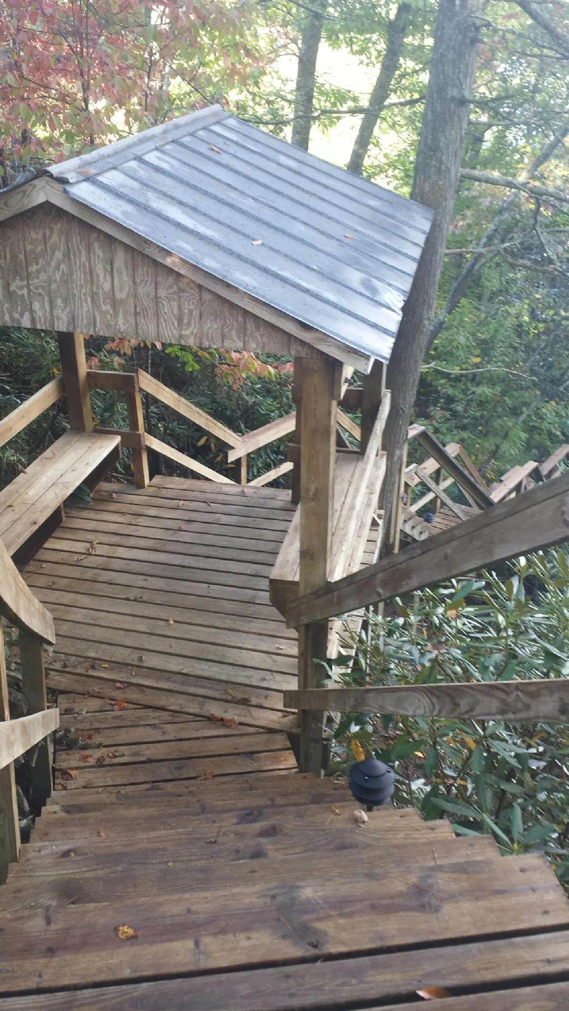 Metal roofed shelter over wooden steps on a wooded walkway — Skylight Repair & Installation work by our crew in Frenchville