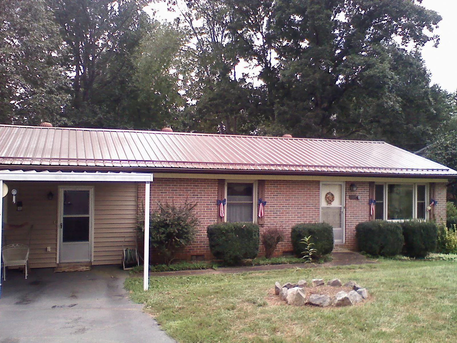 Bronze metal roof and carport on a brick ranch home — Roof Repair work by our crew in Frenchville